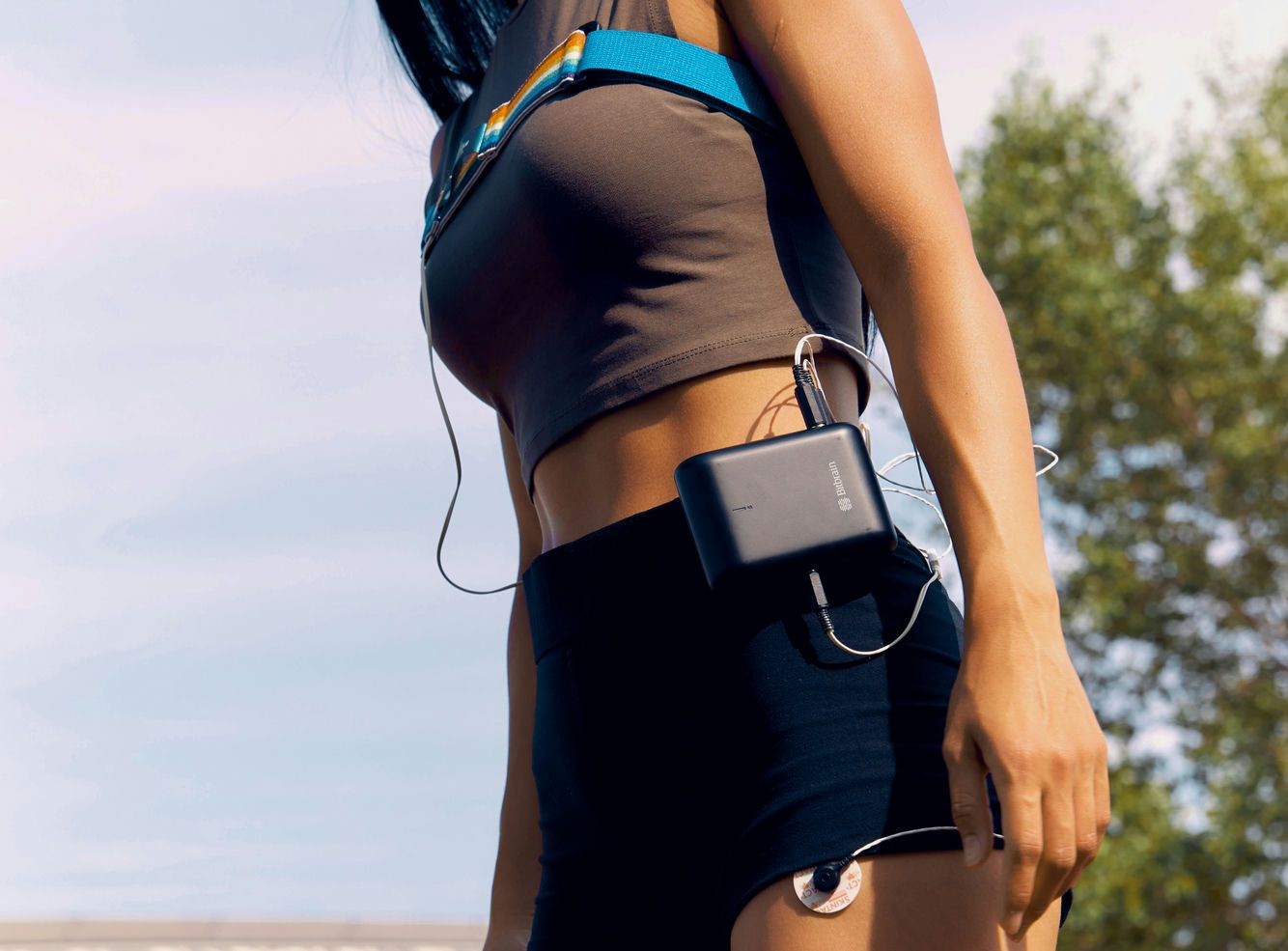 Mujer caminando con el amplificador de bioseñales en la cintura